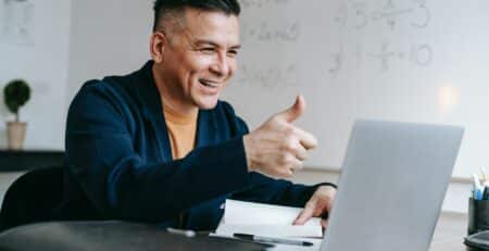 business man giving a thumbs up on a computer video conference